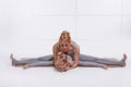 Mother daughter doing yoga exercise,fitness family sports, sports paired woman sitting on the floor stretching his legs apart in