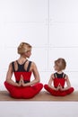 Mother and daughter doing yoga exercise, fitness, gym sports paired
