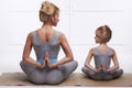 Mother daughter doing yoga exercise, fitness, gym wearing the same comfortable tracksuits, family sports, sports paired