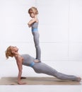 Mother and daughter doing yoga exercise, fitness, gym wearing the same comfortable tracksuits family sports, sports paired woman