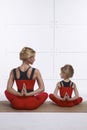 Mother and daughter doing yoga exercise, fitness, gym wearing th