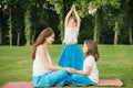 Mother with daughter doing yoga exercise