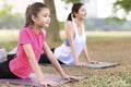 Mother and daughter doing yoga exercises on grass in the park Royalty Free Stock Photo