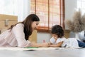 Mother and daughter drawing and coloring with colored pencils lying down on the floor. Happy family moment in the house.Art Royalty Free Stock Photo