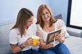 Mother and daughter drinking coffee looking picture at home Royalty Free Stock Photo