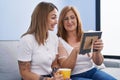 Mother and daughter drinking coffee looking picture at home Royalty Free Stock Photo