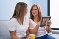 Mother and daughter drinking coffee looking picture at home Royalty Free Stock Photo