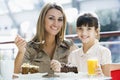 Mother and daughter eating cake in cafe Royalty Free Stock Photo