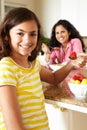 Mother and daughter eating cereal and fruit