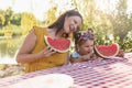 Mother and daughter eating watermelon slice on a picnic