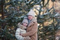 Mother and daughter embracing in a winter park. Happy family. Childhood and parenthood happiness