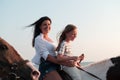 Mother and daughter enjoy riding horses together by the sea. Selective focus Royalty Free Stock Photo