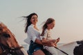 Mother and daughter enjoy riding horses together by the sea. Selective focus Royalty Free Stock Photo