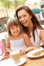 Mother And Daughter Enjoying Cup Of Coffee