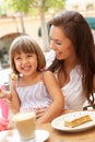 Mother And Daughter Enjoying Cup Of Coffee