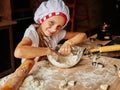 Girl enjoying kneading the dough in the kitchen. Kids at the kitchen. Family housekeeping Royalty Free Stock Photo