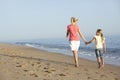 Mother And Daughter Enjoying Walk Along Beach Royalty Free Stock Photo
