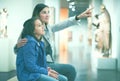 Mother and daughter exploring antique statues