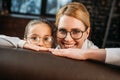 mother and daughter in eyeglasses looking at camera while hiding