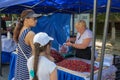 A mother and daughter at the farmers market buying fruit