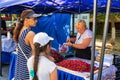 A mother and daughter at the farmers market buying fruit