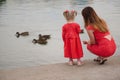 Mother with daughter feeding ducks in park Royalty Free Stock Photo