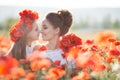 Beautiful mother and her daughter playing in spring flower field Royalty Free Stock Photo