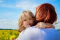 Mother and daughter in a field with yellow dandelions. Family walks in the spring in nature Royalty Free Stock Photo