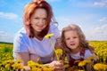 Mother and daughter in a field with yellow dandelions. Family walks in the spring in nature Royalty Free Stock Photo