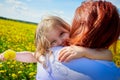 Mother and daughter in a field with yellow dandelions. Family walks in the spring in nature Royalty Free Stock Photo