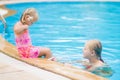 Mother and daughter with flower behind ear have fun at pool side