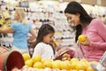 Mother And Daughter At Fruit Counter In Supermarket With List Royalty Free Stock Photo