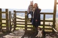 Mother and daughter by a gate in countryside with pet dog Royalty Free Stock Photo