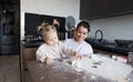 a happy mother and a girl daughter cook cookies and have fun in the kitchen. Homemade food and a little helper. Royalty Free Stock Photo