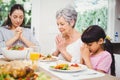 Mother and daughter with granny praying at dining table Royalty Free Stock Photo