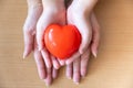 Mother and daughter hands holding red heart, health care, donate and family insurance concept