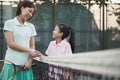 Mother and daughter handshaking over the tennis net