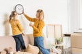 mother and daughter hanging clock on wall during