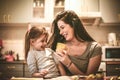 Mother and daughter have fun in home kitchen.