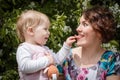 Mother and daughter have fun in the park and apple tree with white flowers Royalty Free Stock Photo