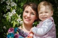 Mother and daughter have fun in the park and apple tree with white flowers Royalty Free Stock Photo