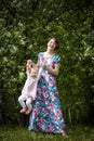 Mother and daughter have fun in the park and apple tree with white flowers Royalty Free Stock Photo