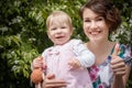 Mother and daughter have fun in the park and apple tree with white flowers Royalty Free Stock Photo