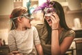 Mother and daughter have play with carnival mask.