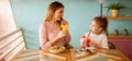 Mother and daughter having a breakfast with fresh squeezed juices in the cafe Royalty Free Stock Photo