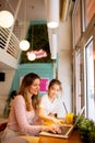 Mother and daughter having a breakfast with fresh squeezed juices in the cafe Royalty Free Stock Photo