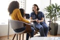 Mother And Daughter Having Consultation With Female Pediatrician Wearing Scrubs In Hospital Office Royalty Free Stock Photo