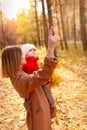 Mother and daughter having fun in autumn park. Happy family on walk. Royalty Free Stock Photo