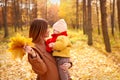 Mother and daughter having fun in autumn park. Happy family on walk. Royalty Free Stock Photo