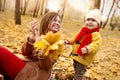 Mother and daughter having fun in autumn park. Happy family on walk. Royalty Free Stock Photo